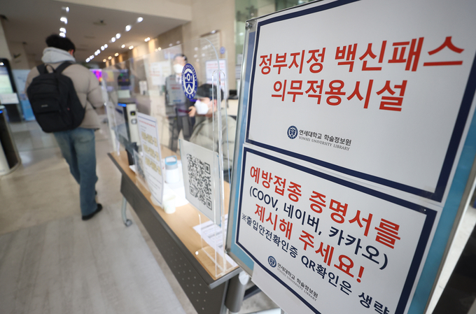 지난 12일 서대문구 연세대학교 중앙도서관 입구에서 한 학생이 백신 접종 증명서를 보여준 뒤 입장하고 있다. 연세대는 오는 13일부터 중앙도서관에서 방역패스를 시행하기로 했다. (사진=연합뉴스)