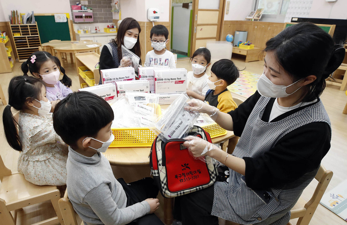 2일 오전 한 어린이집에서 교사가 원생들에게 자기진단키트를 배부하고 있다. (사진= 연합뉴스 제공)