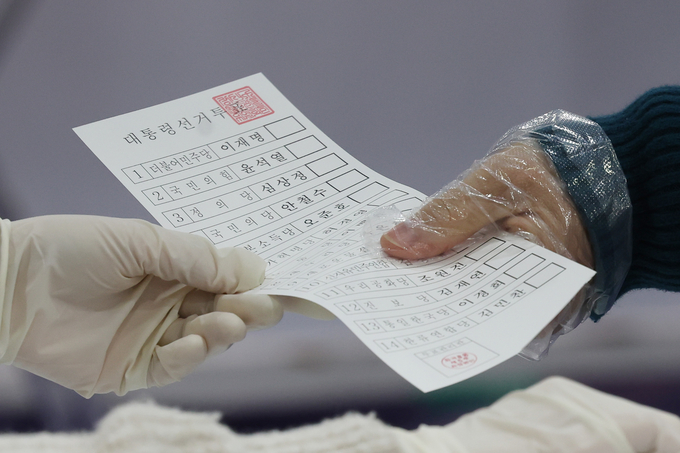 제20대 대통령선거일인 9일 오전 한 투표소에서 유권자가 투표용지를 받고 있다. (사진= 연합뉴스 제공)