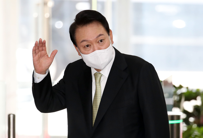 12일 윤석열 대통령이 출근길 '원거리' 도어스테핑을 재개하며 기자단에 손을 들어 인사하고 있다. (사진=연합뉴스 제공)