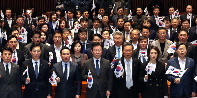 이재명 더불어민주당 대표와 의원들이 16일 오후 국회에서 열린 의원총회에서 태극기를 들고 ‘대일 굴욕외교 중단하라’ 구호를 외치고 있다. (사진=연합뉴스)