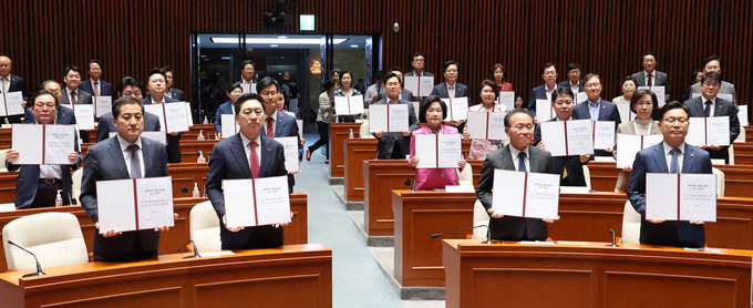 국민의힘 국회의원들이 21일 국회에서 열린 의원총회에 참석해 불체포특권 포기 서약서에 서명했다. (사진=연합뉴스)