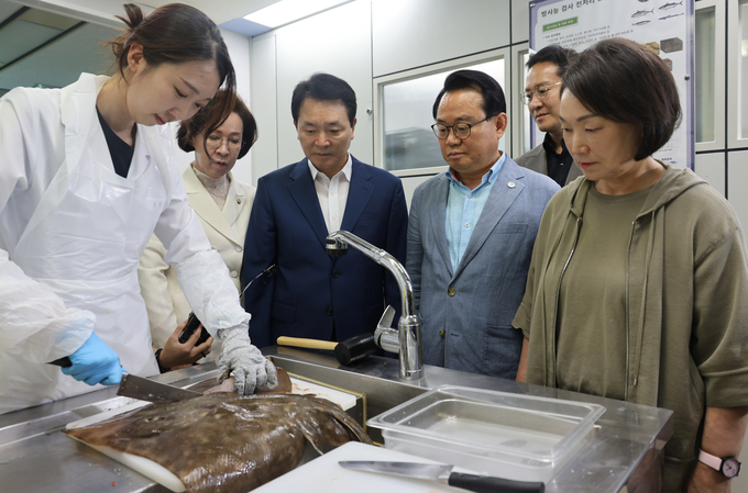 국민의힘 ‘우리 바다 지키기 TF’ 소속 국회의원들이 지난 25일 부산 수입식품 검사소에서 식약처 직원이 일본 수산물을 검사하기 위해 전처리 작업을 하는 모습을 지켜보고 있다.