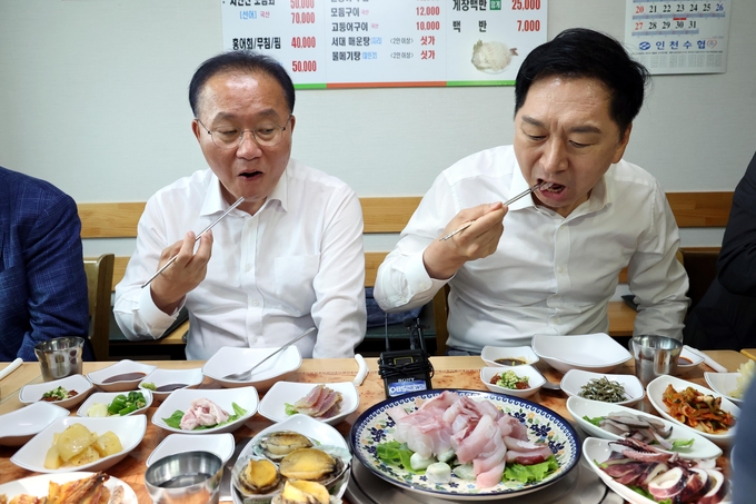 국민의힘 김기현 대표(오른쪽)와 윤재옥 원내대표가 29일 인천 을왕리의 한 횟집을 찾아 회를 먹고 있다. (사진=연합뉴스)