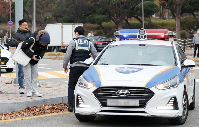 16일 오전 인천 미추홀구 선인고 앞에서 순찰차를 타고 도착한 수험생이 경찰관에게 감사의 인사를 하고 있다. ( 사진 = 연합뉴스 제공 )