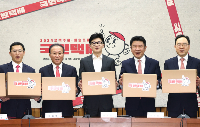 국민의힘 한동훈 비상대책위원장과 윤재옥 원내대표 등이 15일 국회에서 열린 제22대 총선 공약개발본부 출범식에서 ‘정책 주문, 배송 프로젝트’를 상징하는 택배상자를 들고있다. (사진=연합뉴스)