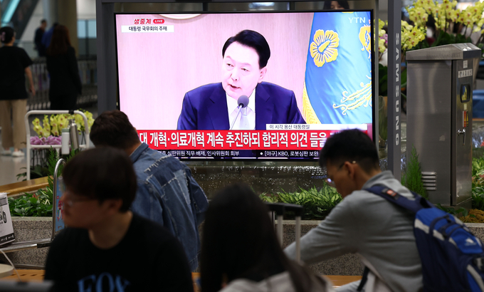 국무회의 지켜보는 인천공항 이용객들. (사진=연합뉴스)