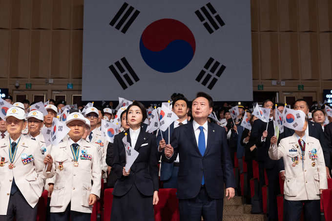 윤석열 대통령과 김건희 여사가 25일 대구 엑스코에서 열린 ‘6.25전쟁 제74주년 행사’에서 6.25의 노래를 부르며 태극기를 흔들고 있다. (사진=연합뉴스)