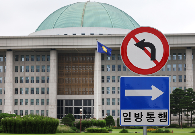 국회 정문 입구에 설치된 일방통행, 좌회전금지 교통 표지판 너머로 본청이 보인다. (사진=연합뉴스)