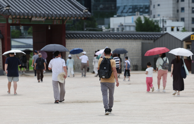 여름철 무더위에 시민들이 양산을 쓰고 있다. ( 사진 = 연합뉴스 )