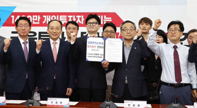 국민의힘 한동훈 대표와 추경호 원내대표 등 참석자들이 24일 국회에서 열린 ‘1400만 개인투자자 살리는 금융투자소득세 폐지’ 촉구 건의서 전달식에서 기념촬영을 하고 있다. (사진=연합뉴스)