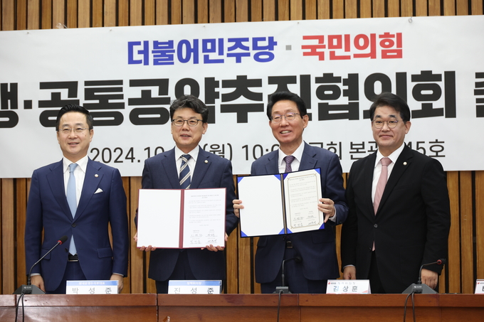 (왼쪽부터) 박성준 더불어민주당 원내수석부대표, 진성준 정책위의장, 김상훈 국민의힘 정책위의장, 배준영 원내수석부대표가 28일 국회에서 열린 민주당-국민의힘 민생·공통 공약 추진 협의기구 출범식에서 합의문에 서명한 뒤 취재진을 향해 포즈를 취하고 있다. (사진=연합뉴스) 