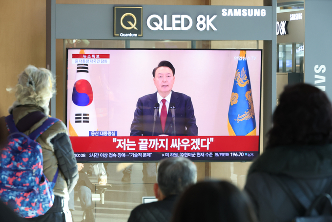 12일 오전 서울역에서 시민들이 윤석열 대통령 담화를 TV로 보고 있다. (사진=연합뉴스 제공)