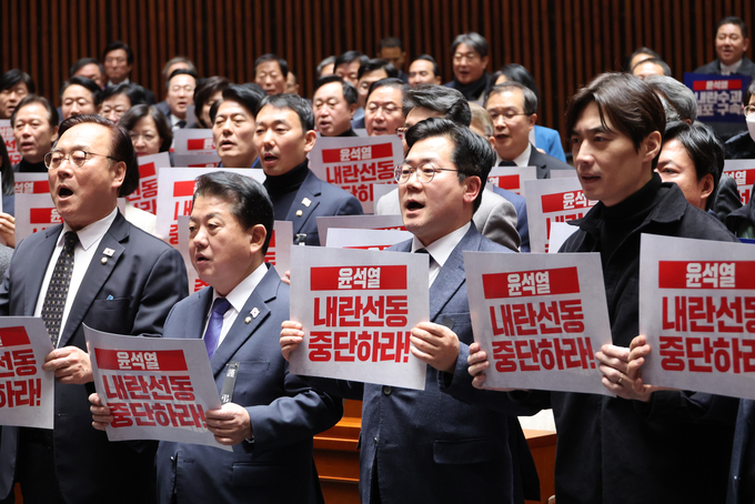더불어민주당 국회의원들이 2일 오후 국회 예결위회의장에서 열린 비상의원총회에 참석해 ‘윤석열 내란선동 중단하라’,고 적힌 피켓을 들고 구호를 외치고 있다. (사진=연합뉴스)