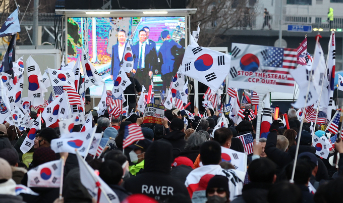 윤석열 대통령이 서울구치소에서 석방돼 한남동 관저로 돌아온 8일 윤 대통령 지지자들이 관저 앞에서 태극기를 흔들고 있다. (사진=연합뉴스)