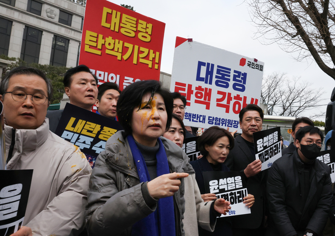 백혜련(민주·수원을) 의원이 20일 서울 종로구 헌법재판소 앞에서 열린 민주당 원내부대표단의 윤석열 대통령 신속 파면 촉구 기자회견에서 얼굴에 계란을 맞은 채 회견을 이어가고 있다. (사진=연합뉴스)