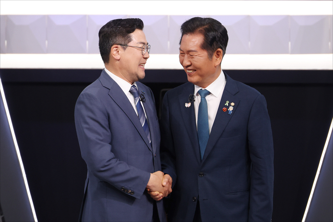 정청래(오른쪽)·박찬대 더불어민주당 당대표 후보가 27일 KBS 신관 공개홀에서 열린 당대표 후보자 2차 토론회 시작 전 악수를 나누며 웃음 짓고 있다. (사진=연합뉴스)